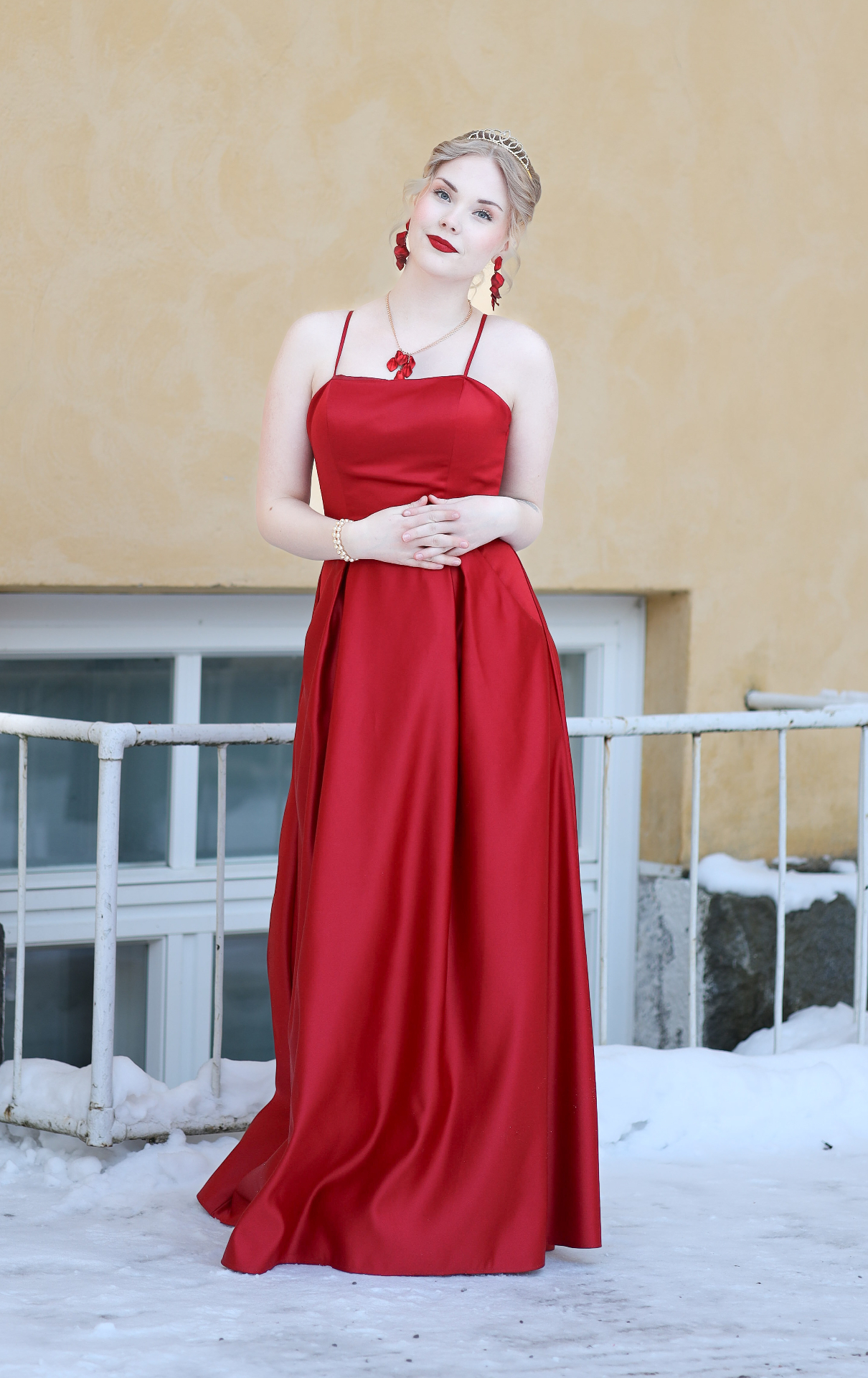 Young woman in red gown and tiara in winter light