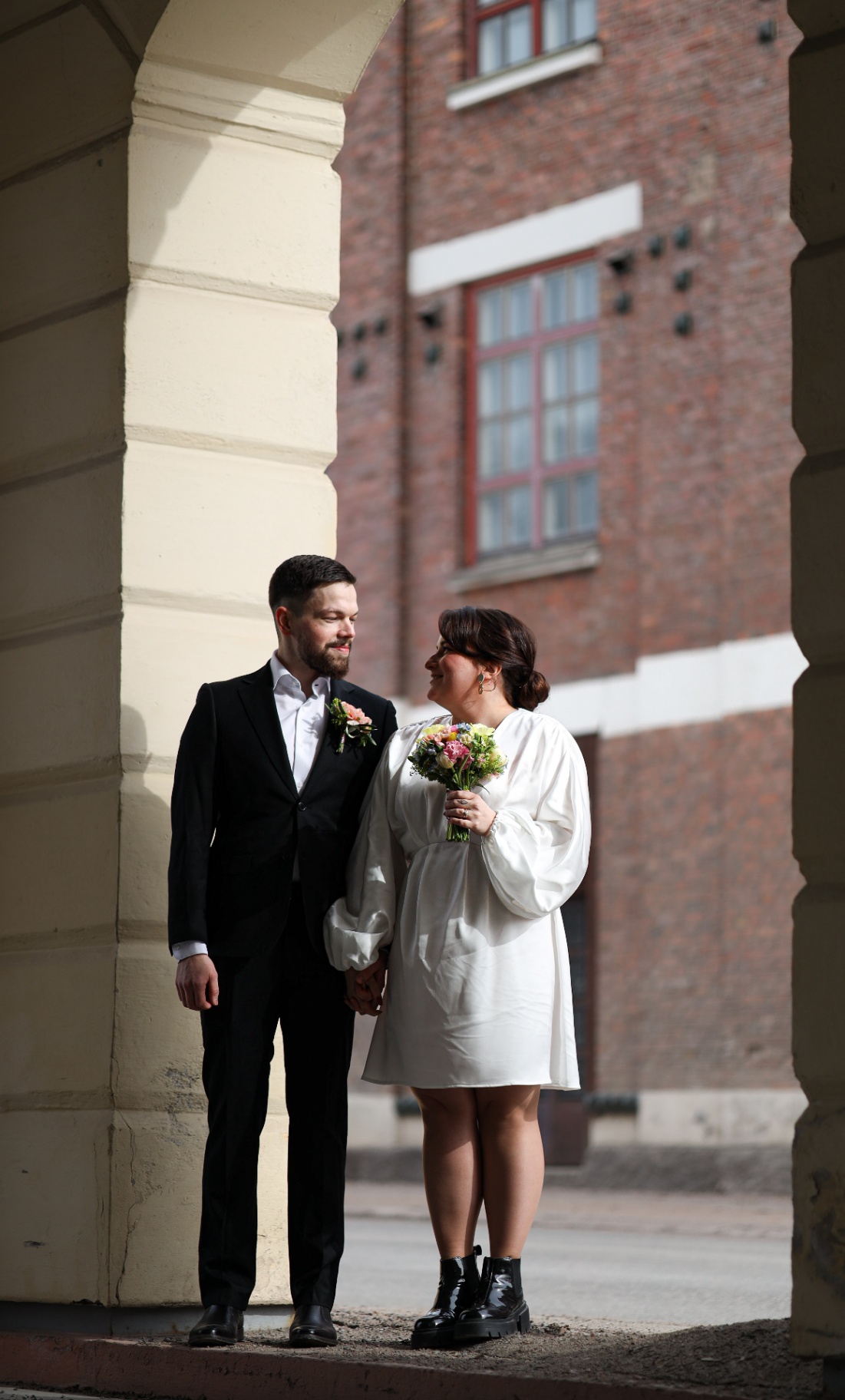 Bride and groom at a sunlit archway