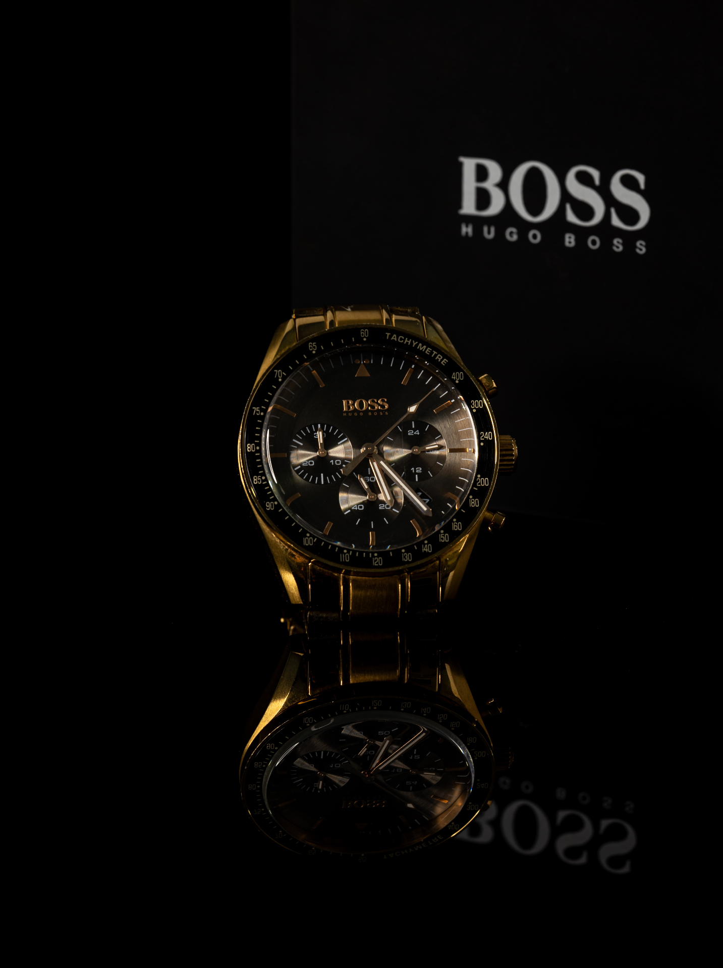 Gold chronograph watch in dramatic low-key light