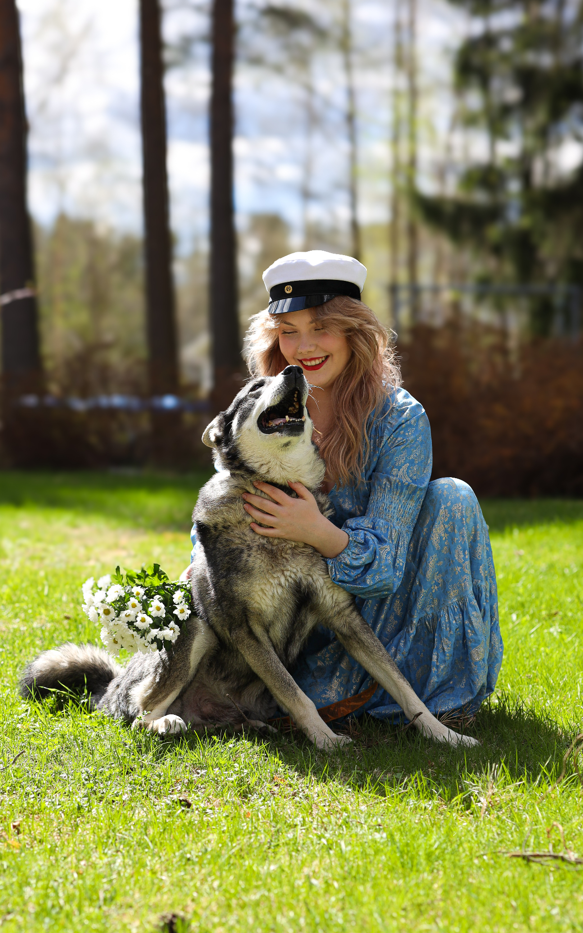 Graduate in student cap laughing with her dog